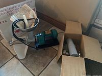 Side view of motor and squeezer body with stainless steel funnel and plunger inserted