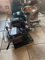 Two Reber electric tomato press units side by side showing front and side profiles