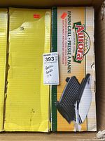 Two boxes containing Aurora Panini Grill units showing branding and product features