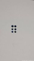 Five small round royal blue natural sapphires arranged in a grid, showing their color and cut.