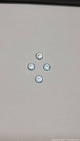 Four natural sky blue topaz gemstones arranged in a diamond shape on a neutral background.