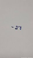 Five oval cut tanzanite gemstones displayed on white background, showing purple-blue color and clarity.
