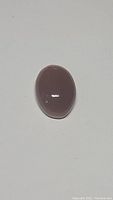 Oval cabochon cut moonstone gemstone, smooth and polished with chocolate brown color and subtle cat's eye effect.