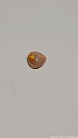 Pear-shaped natural Ethiopian opal cabochon with butterscotch background and rainbow flash, shown on white background.