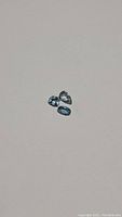 Three deep blue aquamarine stones on white backdrop showing overall shape and color