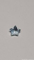 Close-up of star-shaped aquamarine gemstone showing the cut and clarity.