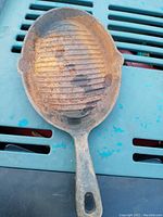 Top-down view showing oval cast iron skillet with rust and residue