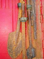 Five different Hilti chisels, all heavily rusted and scratched, lying side by side on a red surface.
