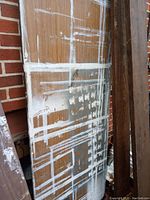 Photo of a six-foot foldable table with a wooden top heavily splattered with white paint and some rust on metal folding legs.