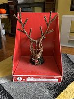 Reindeer-shaped Christmas tree topper in red display box viewed from front with lights off.