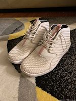 Side view of white Jordan sneakers showing textured woven pattern and lace-up front