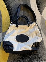 White and black Tommy Hilfiger purse bag showing overall front view with handles and strap