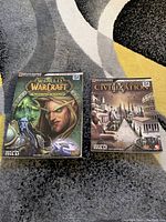 Front covers of World of Warcraft and Civilization 4 strategy guides showing artwork and condition