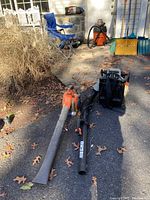 Two leaf blowers on driveway alongside accessories
