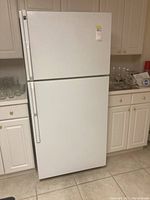 Front view of white Hotpoint refrigerator in a kitchen, showing overall condition and design.