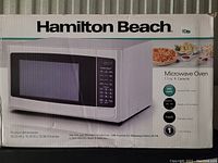 Box of Hamilton Beach microwave oven showing the product image and key features including 1.1 cu. ft. capacity and 1000 watts power.
