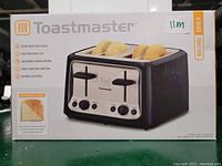 Photo of box showing Toastmaster 4-slice toaster with extra wide slots and key features.