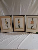 Three framed military prints laid out side by side showing British Dragoons in vintage uniforms.