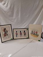 Group photo showing three vintage British military prints including two framed Highlander prints and one unframed print.