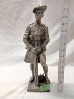Front view of bronze Highlander soldier statuette with ruler for scale