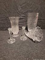 Photo showing two cut crystal vases, two candlesticks and one cornucopia vase with detailed cut patterns.