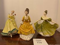 Front view of three figurines on wooden surface