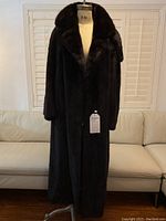 Full front view of coat from collar to hem on dress form against a white background