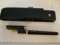 Pen and leather pouch laid flat, cap removed to show rollerball tip
