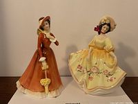 Front view of both figurines side by side on tabletop