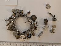 Overall layout showing bracelet loaded with charms and loose charms to the right