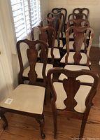 Set of wooden dining chairs arranged in two rows showing 8 side chairs.