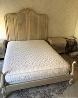 Front view of assembled bed frame with mattress and two nightstands