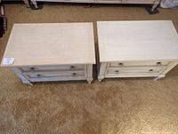 Top view of the two bedside tables placed side by side showing light painted finish and slight surface wear