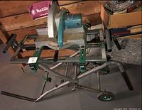 Photo overview of the hitachi miter saw stand with miter saw on top, showing entire stand and wheels for mobility.