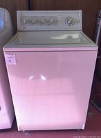 Front view of white Kenmore Elite top-load washing machine with control panel and glass lid.