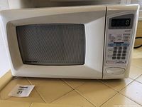 Front view of white Magic Chef microwave with digital keypad and display, showing the brand logo and model style.