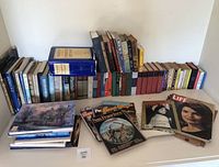 Wide shot of multiple vintage books arranged on a shelf and three vintage magazines laid out in front.