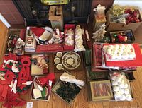 Full overview of the Christmas decor items spread on a wooden floor including Santa figurines, stockings, plates, and ornaments