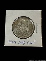 Front side of the 1964 Canadian 50 cent coin showing the Canadian coat of arms and denomination.
