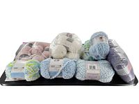 Various yarn skeins arranged on a tray including white, blue, purple, and multicolor fluffy yarns.