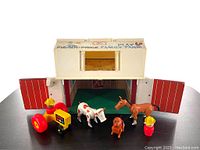 Front view of barn with doors open showing interior and accessories including toy horse, cow, dog, farmer figures, and tractor with trailer