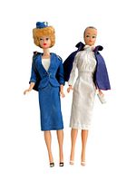Full frontal view of both Barbie dolls showing one in American Airlines stewardess outfit with blue skirt suit and the other in white nurse uniform with blue cape.