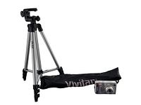 Vivitar tripod with silver legs and black locking parts standing next to black Vivitar carrying bag and vintage silver Fujifilm digital camera