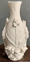 Front view of white Blanc de Chine porcelain vase showing figural dragon and floral decoration.