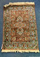 Full view of the Persian carpet showing its pattern, color and fringes on shorter edges