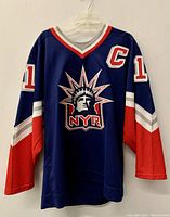 Front view of navy blue hockey jersey showing Statue of Liberty NYR logo, number 11 on sleeves, and captain C patch on chest.