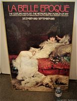 Framed La Belle Epoque exhibition poster showing the full image of a woman in white with a dog on a red chaise.