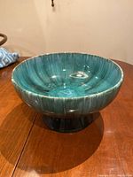 Image showing textured turquoise glaze on inside and outside of Blue Mountain Pottery bowl on a wooden surface.