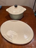 Overhead shot showing both the large covered casserole dish and the oval platter on table.