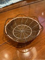 Top and angled view of the small round decorative bowl made with gold and bronze glass beads, showing detailed beadwork and structural framework.